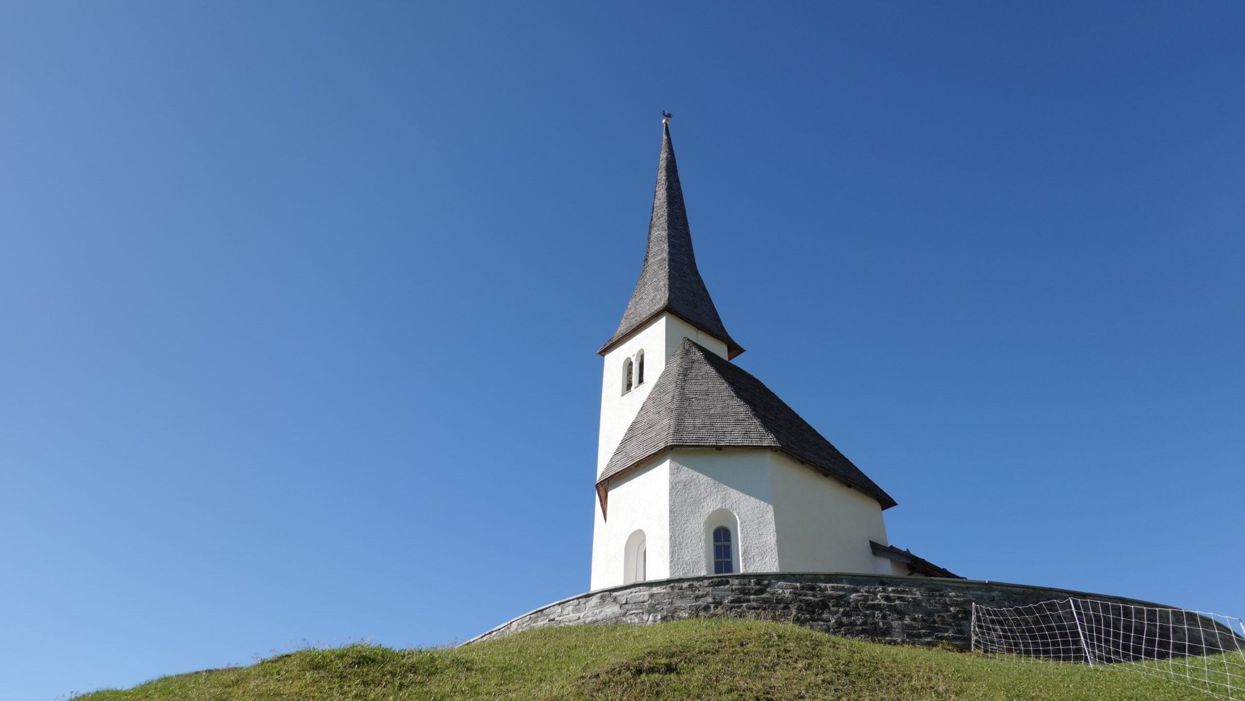 Church building with a steeple against a blue sky